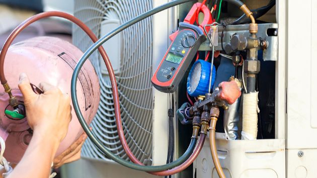 repair person working on an air conditioning unit