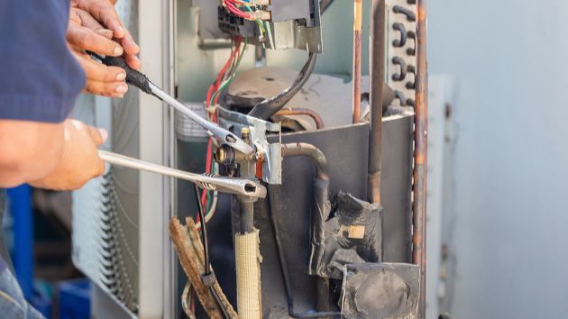 Technician fixing an air conditioning unit.