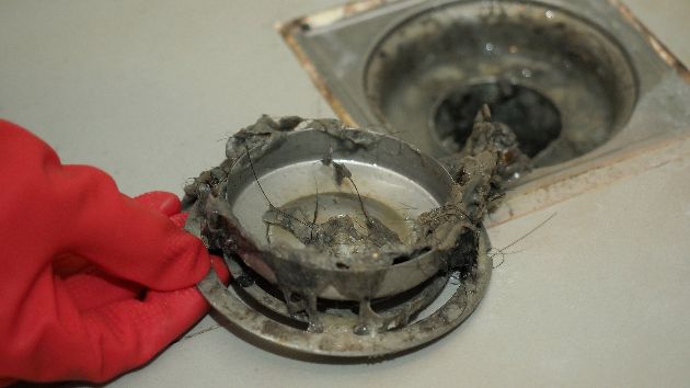 Repair person fixing a clogged drain