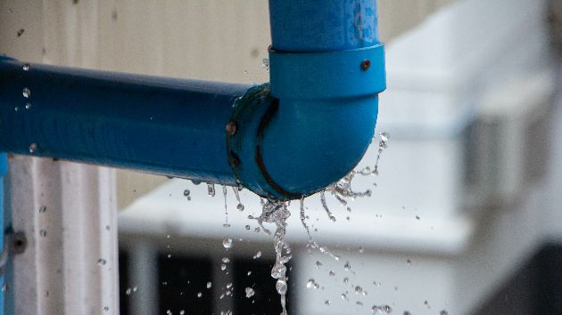 A burst pipe with water leaking out of it.