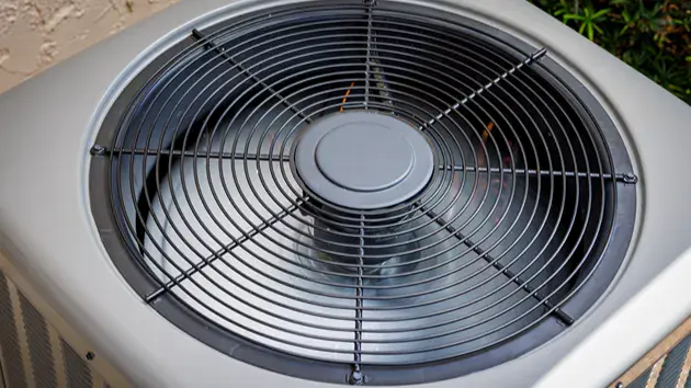 Inside of an AC unit with the motor causing the fans to circulate.