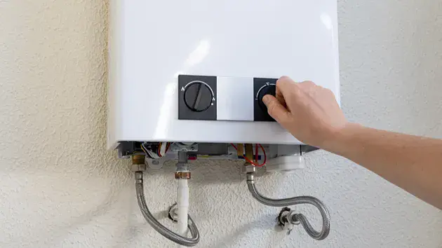 Electric Furnace Repair After A Power Outage Person adjusting the settings on an electric furnace after a power outage.